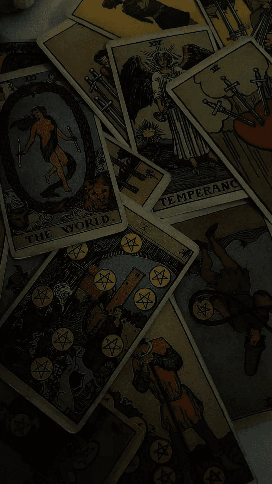Tarot cards spread across a dark table, including The World and Temperance